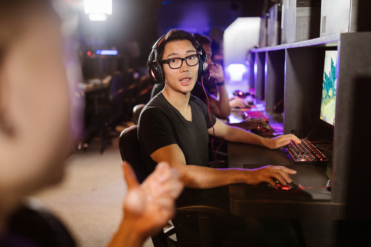 Adult men engaged in competitive video gaming at a modern arcade setting.